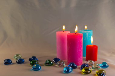 Arkaplanı yanan küçük bir alevi olan ince bir mum. Mumlar eski bir masada. Güzel koyu arkaplan. Dini kavram.