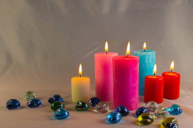 Arkaplanı yanan küçük bir alevi olan ince bir mum. Mumlar eski bir masada. Güzel koyu arkaplan. Dini kavram.