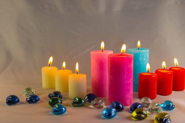 Arkaplanı yanan küçük bir alevi olan ince bir mum. Mumlar eski bir masada. Güzel koyu arkaplan. Dini kavram.