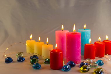 Arkaplanı yanan küçük bir alevi olan ince bir mum. Mumlar eski bir masada. Güzel koyu arkaplan. Dini kavram.