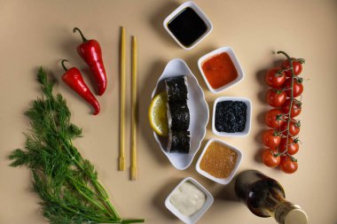 Hafif bir arka planda bir suşi rulosu servis edilir. Suşili lezzetli geleneksel Japon yemekleri..