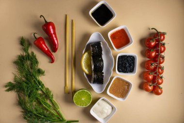 Hafif bir arka planda bir suşi rulosu servis edilir. Suşili lezzetli geleneksel Japon yemekleri..