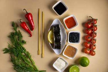 Hafif bir arka planda bir suşi rulosu servis edilir. Suşili lezzetli geleneksel Japon yemekleri..