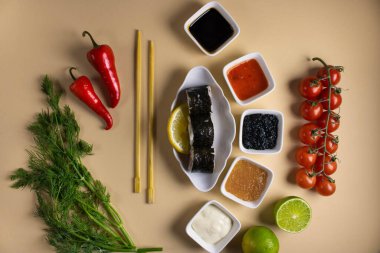 Hafif bir arka planda bir suşi rulosu servis edilir. Suşili lezzetli geleneksel Japon yemekleri..