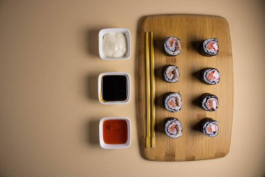 Hafif bir arka planda bir suşi rulosu servis edilir. Suşili lezzetli geleneksel Japon yemekleri..