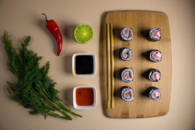 Hafif bir arka planda bir suşi rulosu servis edilir. Suşili lezzetli geleneksel Japon yemekleri..