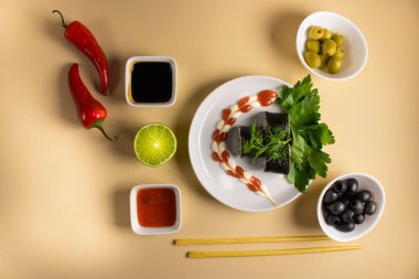 Hafif bir arka planda bir suşi rulosu servis edilir. Suşili lezzetli geleneksel Japon yemekleri..