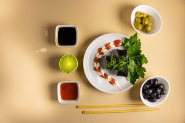 Hafif bir arka planda bir suşi rulosu servis edilir. Suşili lezzetli geleneksel Japon yemekleri..