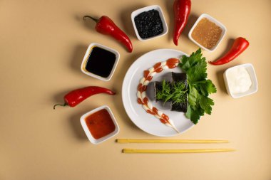 Hafif bir arka planda bir suşi rulosu servis edilir. Suşili lezzetli geleneksel Japon yemekleri..