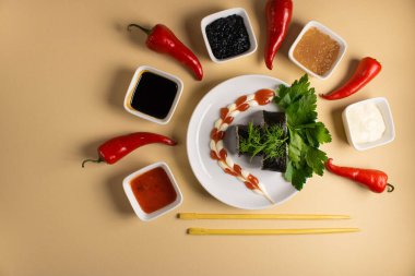 Hafif bir arka planda bir suşi rulosu servis edilir. Suşili lezzetli geleneksel Japon yemekleri..