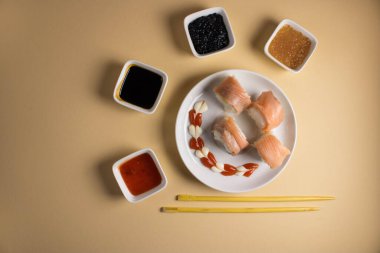 Hafif bir arka planda bir suşi rulosu servis edilir. Suşili lezzetli geleneksel Japon yemekleri..