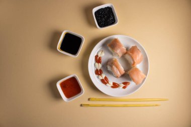 Hafif bir arka planda bir suşi rulosu servis edilir. Suşili lezzetli geleneksel Japon yemekleri..