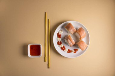 Hafif bir arka planda bir suşi rulosu servis edilir. Suşili lezzetli geleneksel Japon yemekleri..