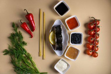 Hafif bir arka planda bir suşi rulosu servis edilir. Suşili lezzetli geleneksel Japon yemekleri..