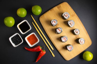 Koyu bir arka planda bir suşi rulosu servis edilir. Suşili lezzetli geleneksel Japon yemekleri..