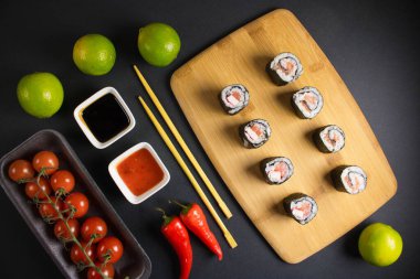 Koyu bir arka planda bir suşi rulosu servis edilir. Suşili lezzetli geleneksel Japon yemekleri..