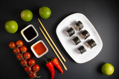 Koyu bir arka planda bir suşi rulosu servis edilir. Suşili lezzetli geleneksel Japon yemekleri..