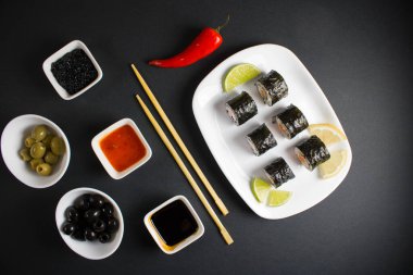 Koyu bir arka planda bir suşi rulosu servis edilir. Suşili lezzetli geleneksel Japon yemekleri..