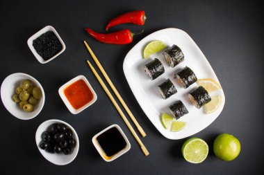 Koyu bir arka planda bir suşi rulosu servis edilir. Suşili lezzetli geleneksel Japon yemekleri..