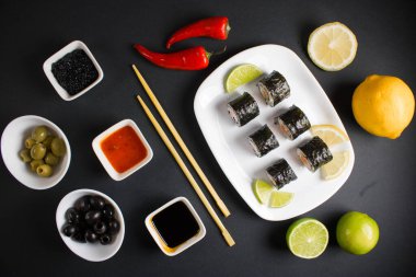 Koyu bir arka planda bir suşi rulosu servis edilir. Suşili lezzetli geleneksel Japon yemekleri..