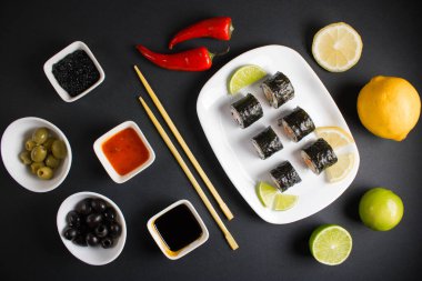 Koyu bir arka planda bir suşi rulosu servis edilir. Suşili lezzetli geleneksel Japon yemekleri..