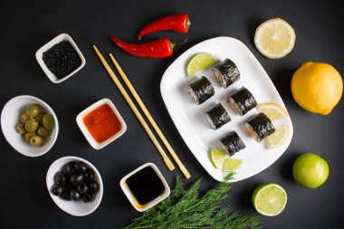 Koyu bir arka planda bir suşi rulosu servis edilir. Suşili lezzetli geleneksel Japon yemekleri..