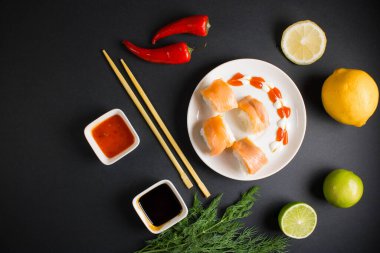 Koyu bir arka planda bir suşi rulosu servis edilir. Suşili lezzetli geleneksel Japon yemekleri..