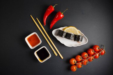 Koyu bir arka planda bir suşi rulosu servis edilir. Suşili lezzetli geleneksel Japon yemekleri..