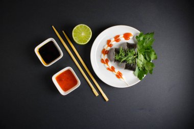 Koyu bir arka planda bir suşi rulosu servis edilir. Suşili lezzetli geleneksel Japon yemekleri..