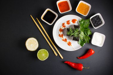 Koyu bir arka planda bir suşi rulosu servis edilir. Suşili lezzetli geleneksel Japon yemekleri..