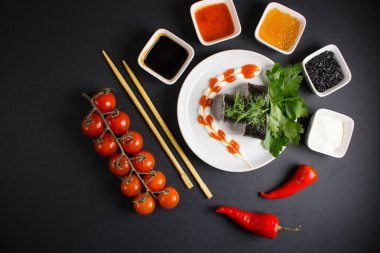 Koyu bir arka planda bir suşi rulosu servis edilir. Suşili lezzetli geleneksel Japon yemekleri..