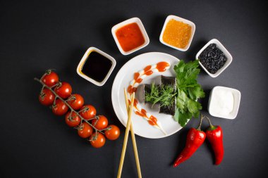 Koyu bir arka planda bir suşi rulosu servis edilir. Suşili lezzetli geleneksel Japon yemekleri..