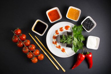 Koyu bir arka planda bir suşi rulosu servis edilir. Suşili lezzetli geleneksel Japon yemekleri..