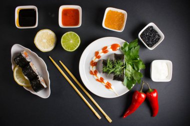 Koyu bir arka planda bir suşi rulosu servis edilir. Suşili lezzetli geleneksel Japon yemekleri..