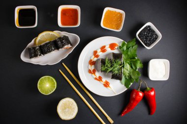 Koyu bir arka planda bir suşi rulosu servis edilir. Suşili lezzetli geleneksel Japon yemekleri..