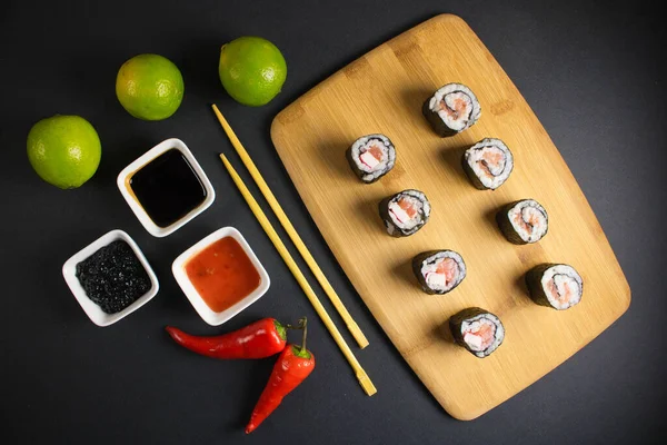 Koyu bir arka planda bir suşi rulosu servis edilir. Suşili lezzetli geleneksel Japon yemekleri..