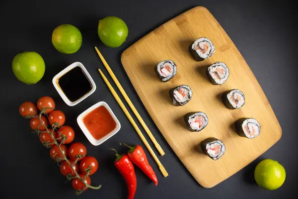 Koyu bir arka planda bir suşi rulosu servis edilir. Suşili lezzetli geleneksel Japon yemekleri..