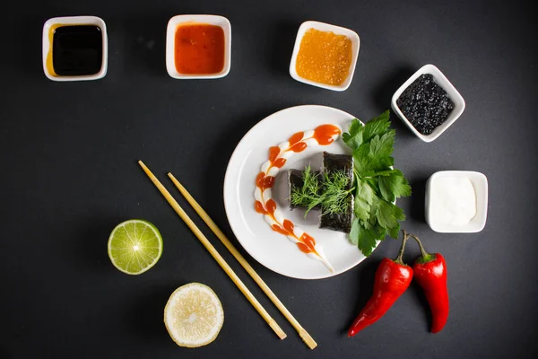 Koyu bir arka planda bir suşi rulosu servis edilir. Suşili lezzetli geleneksel Japon yemekleri..