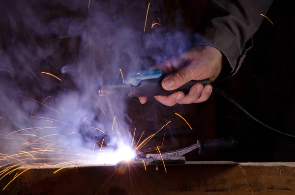 Mans hand with welding machine at workshop