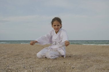 Sahilde Aikido'yu uygulayan bir çocuk. Sağlıklı yaşam tarzı ve spor konsepti