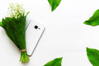beyaz arka plan üzerinde vadi ve akıllı telefon zambaklar