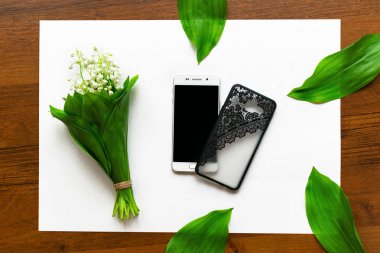 beyaz kağıt üzerinde vadi ve akıllı telefon zambaklar