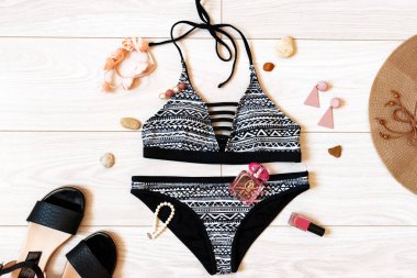 yazlık düz mayo, şapka, sandalet ve aksesuarları ile yatıyordu