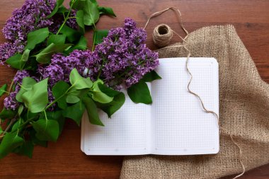 white sheet of notebook on the rustic background of lilac