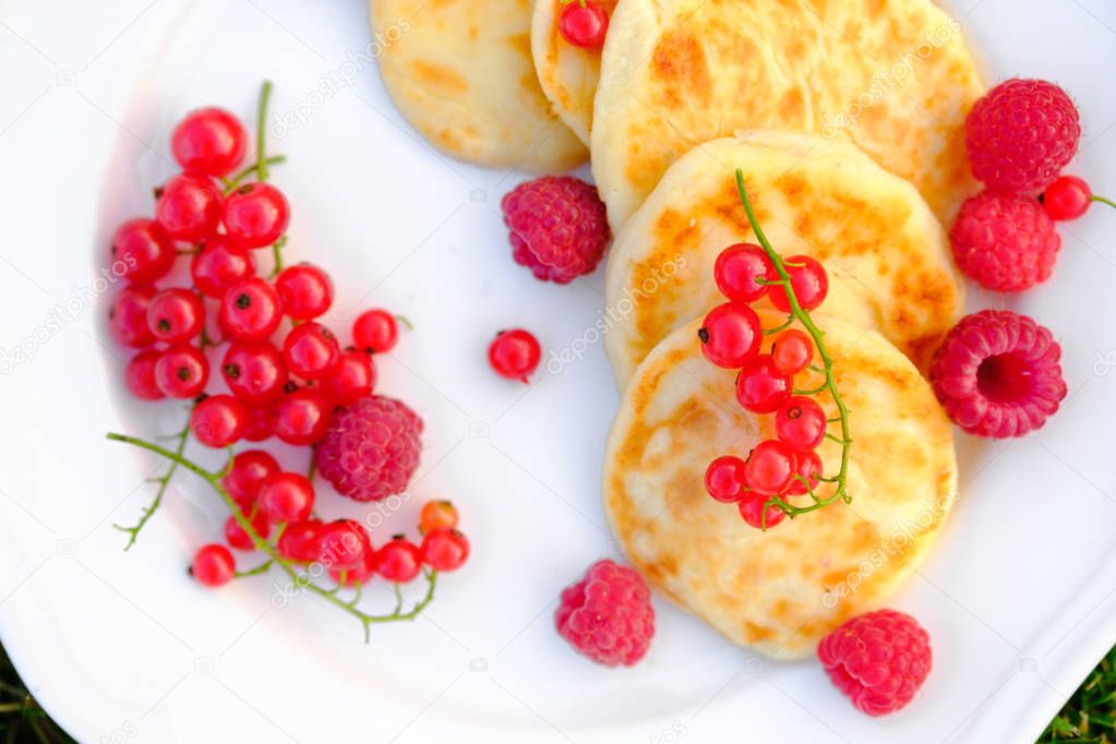 Beautiful cottage cheese pancakes with raspberries and red currants