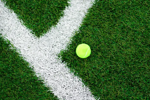 Piłka tenisowa leżąca na trawniku. Sztuczna trawa — Zdjęcie stockowe