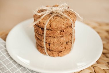 Hafif bir arka planda bir halat ile bağlanmış yulaf ezmesi kurabiye yığını. Gün ışığı