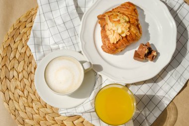 Kahvaltıda kruvasan, çikolata, kahve, portakal suyu ile servis edilir