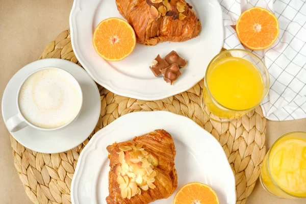 Café con croissants, trozos de chocolate, zumo de naranja y mandarinas para el desayuno — Foto de Stock