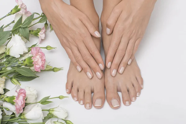 The picture of ideal done manicure and pedicure. Female hands and legs in the spa spot.